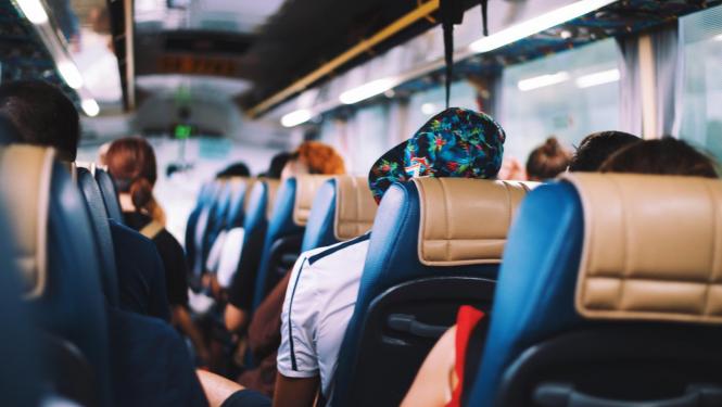 Autobusa salons, kurā sēž cilvēki