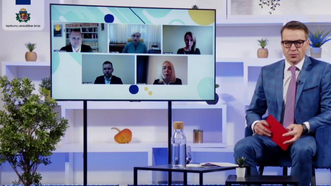 Stopkadrs no konferencnes - moderators studijā ar attālinātajiem runātājiem ekrānā