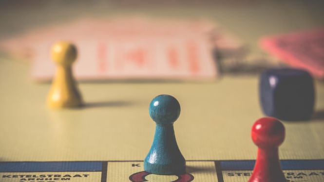 spēļu kauliņš uz monopola laucija ar jautājuma zīmi