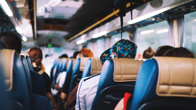 Autobusa salons, kurā sēž cilvēki