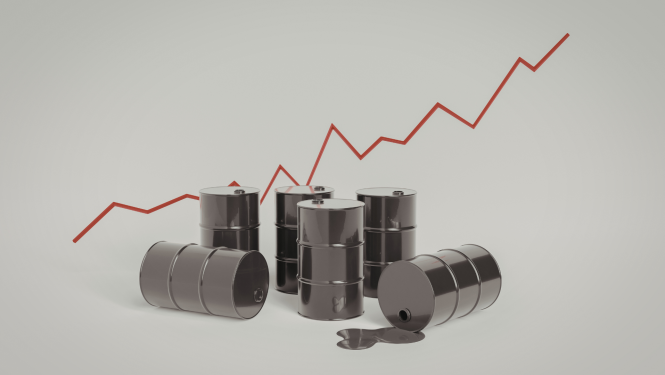 Uz gaiša fona izvietotas vairākas melnas naftas mucas, no vienas izlējies šķidrums. Fonā redzama sarkana, kāpjoša cenu līknes grafiskā līnija.