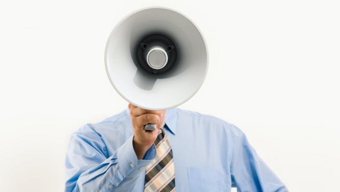 Vīrietis tur rokā skaļruni