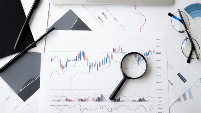 Optiskās brilles un palielināmais stikls (lupa), papīrs ar statistikas zīmējumiem